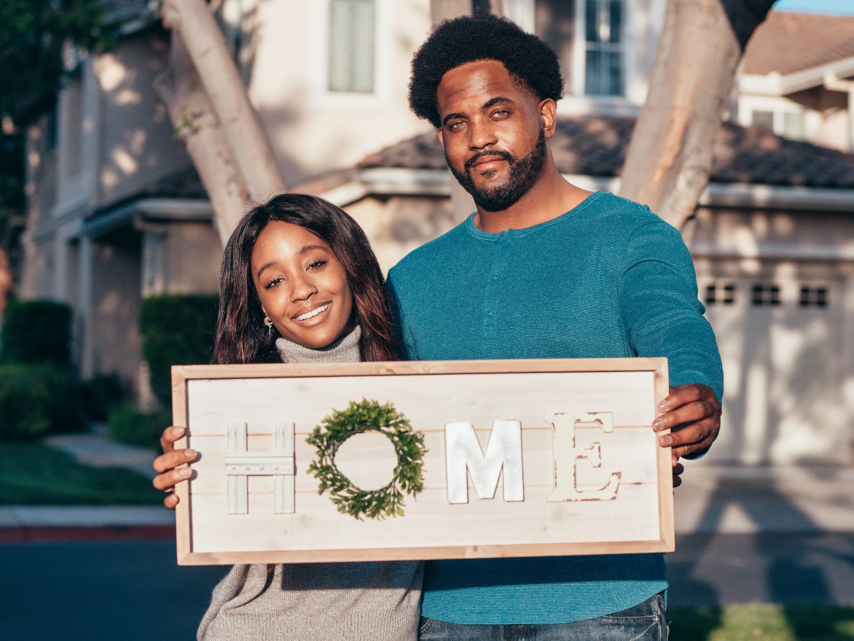 man and woman holding a wooden frame decoration